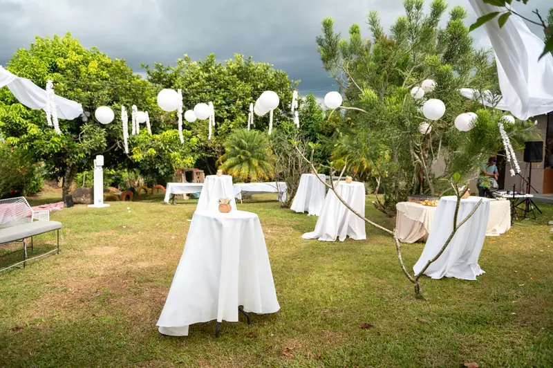 Cóctel al aire libre con mesas altas y lámparas en el jardín